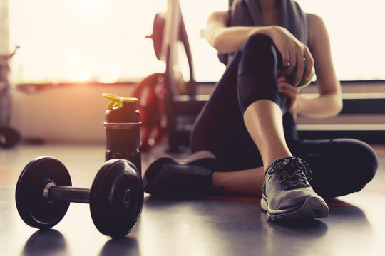 A person sitting on the floor with weights

Description automatically generated